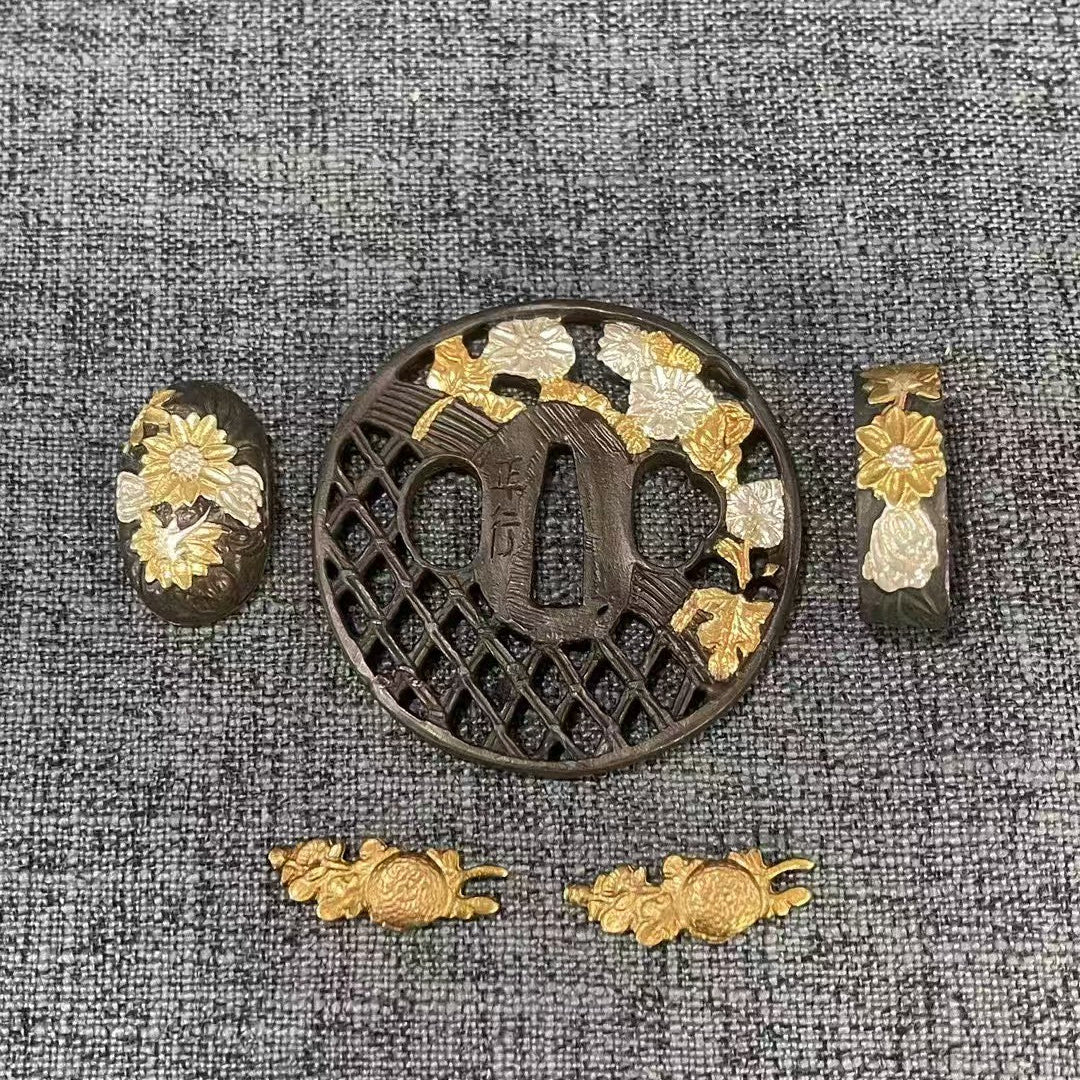 Complete Koshirae set featuring gilded and silvered Kiku (chrysanthemum) flowers on a dark brass Sukashi lattice Tsuba, with matching Fuchi, Kashira, and Menuki.