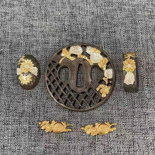 Complete Koshirae set featuring gilded and silvered Kiku (chrysanthemum) flowers on a dark brass Sukashi lattice Tsuba, with matching Fuchi, Kashira, and Menuki.