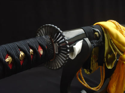 A detailed close-up of the Kiku's Reflection Katana, showcasing the iron Kiku (Chrysanthemum) tsuba, black cord ito, and red genuine rayskin.