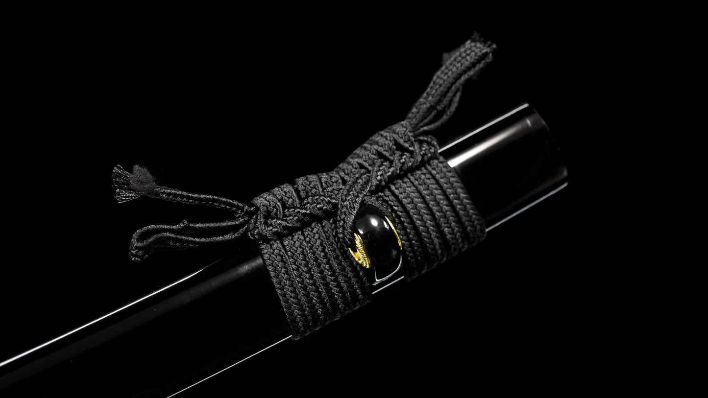 Close-up of the black lacquer saya's kurikata and woven black sageo cord.