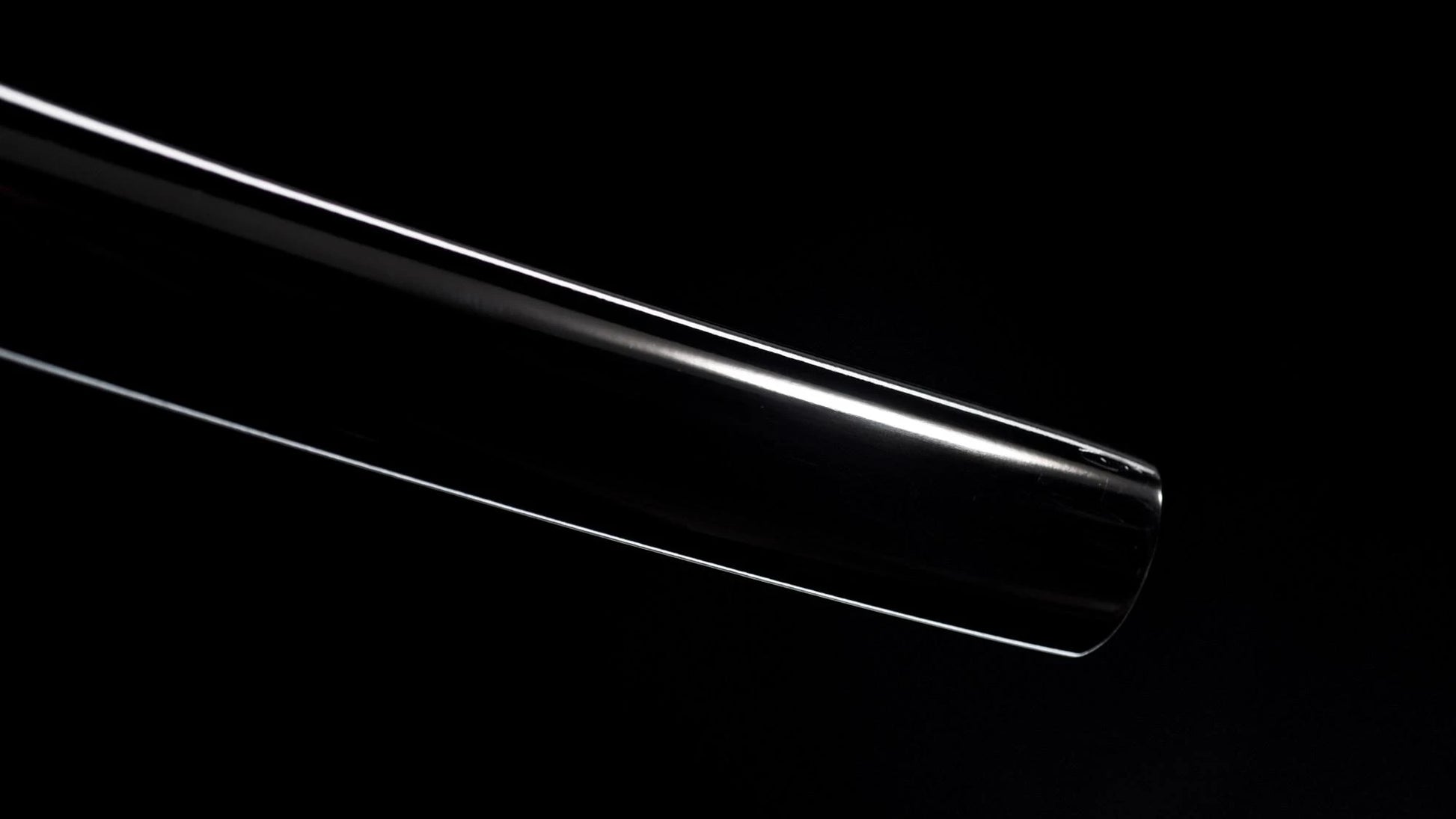 Polished folded-steel nodachi blade with a deep curve against a black background.