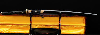 The complete Golden Hawk Katana, sheathed in its gloss-black and partial brown rayskin saya, resting on a stand in its display box.