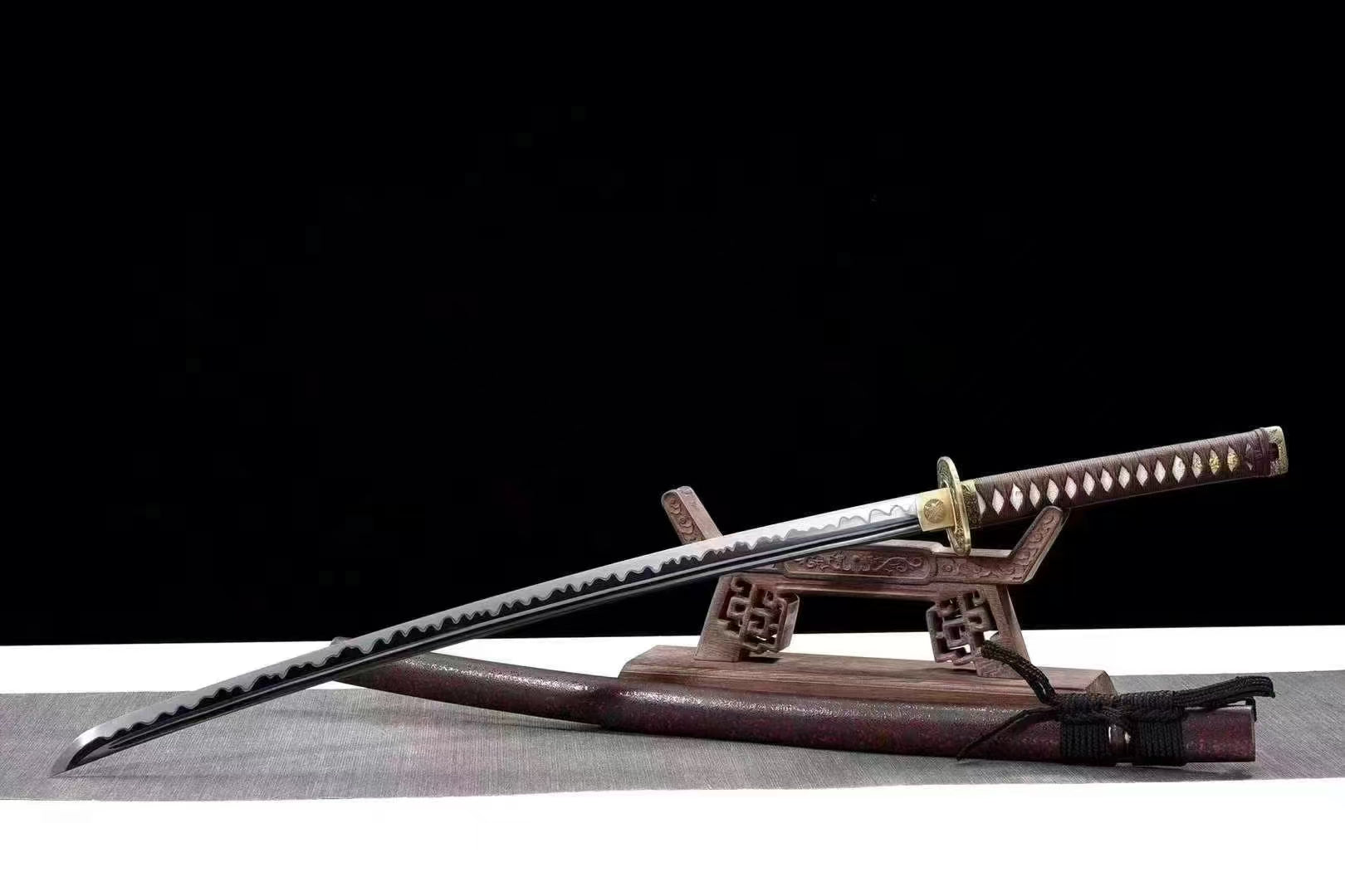 The Phoenix Fire Katana, sheathed in its reddish-brown speckled lacquer saya, resting on a display stand.