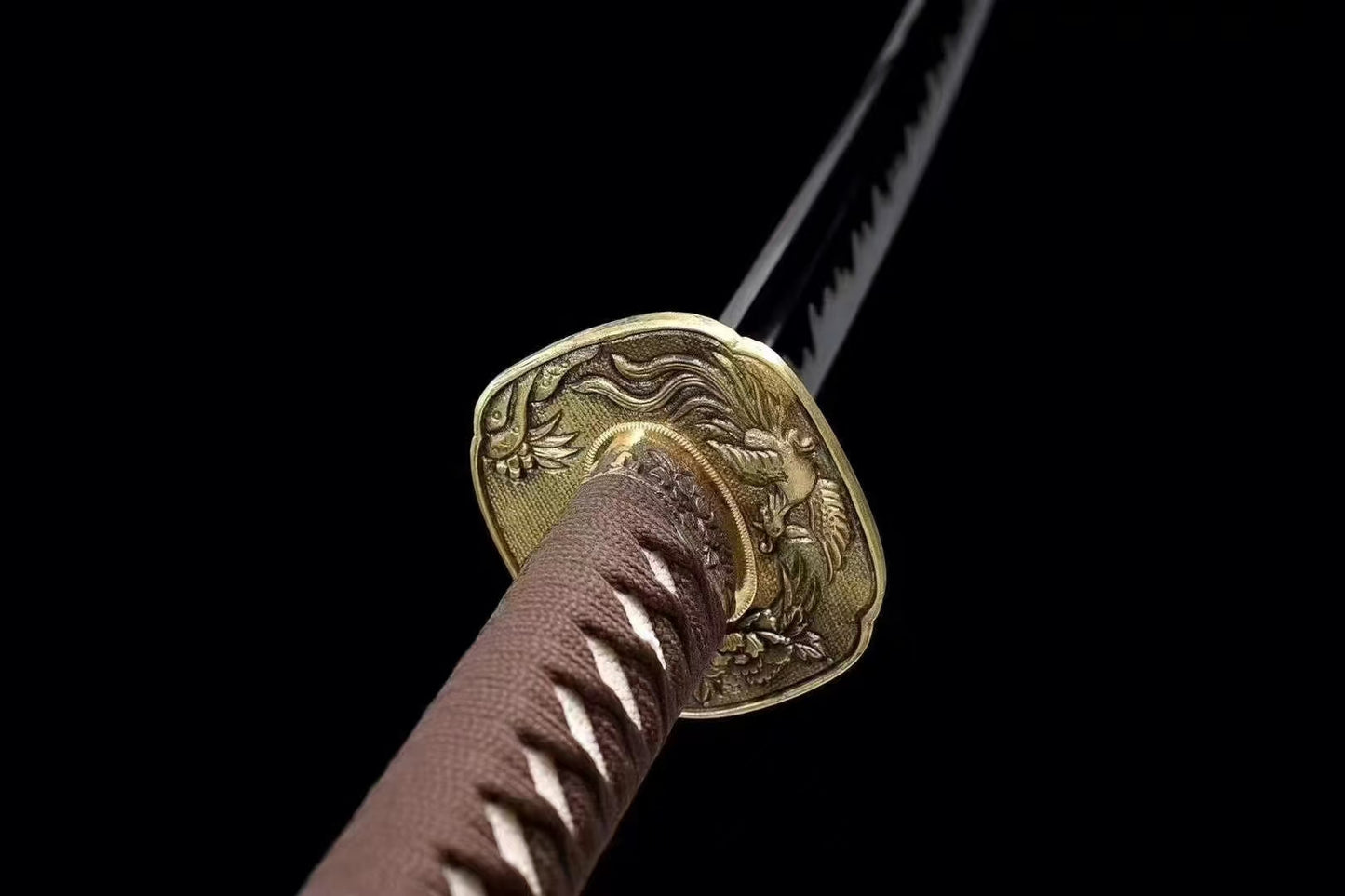 A close-up of the brass tsuba (guard), featuring an intricate Phoenix (Hō-ō) theme.