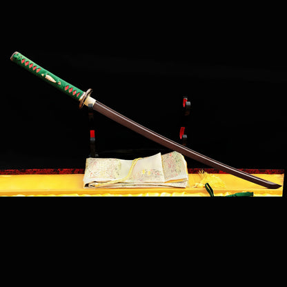 The unsheathed Nishikigoi Katana displayed on a stand, highlighting the unique red & black folded steel blade and its green & red handle.