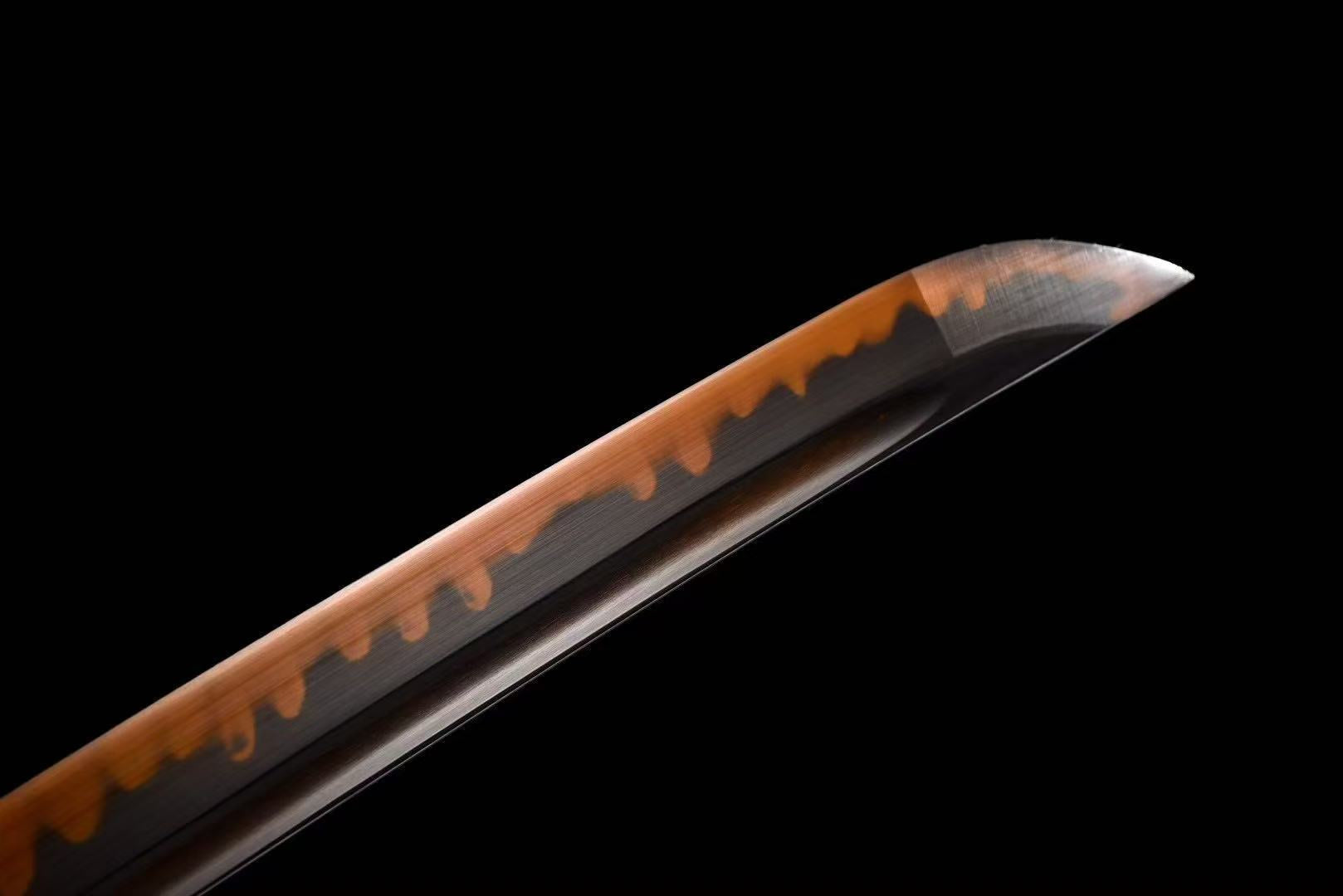 A close-up of the chu-kissaki tip, with the red clay-tempered hamon extending to the point of the blade.