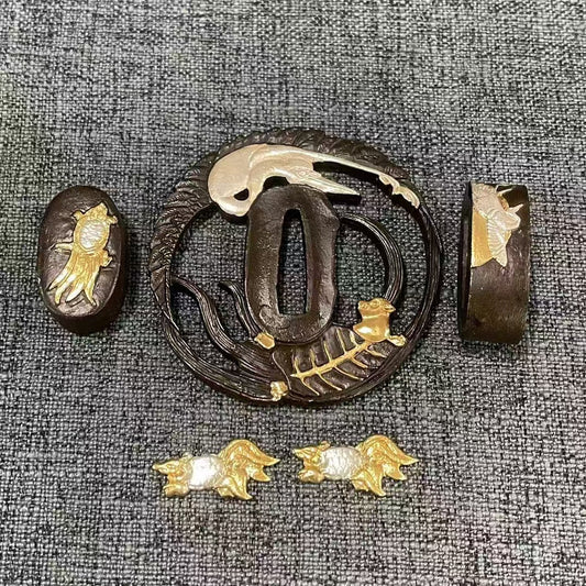 Complete Koshirae set featuring a silvered Sagi (heron) and gilded Shishi (lion) on a textured black brass Sukashi Tsuba, with matching dual-tone Fuchi, Kashira, and Menuki.