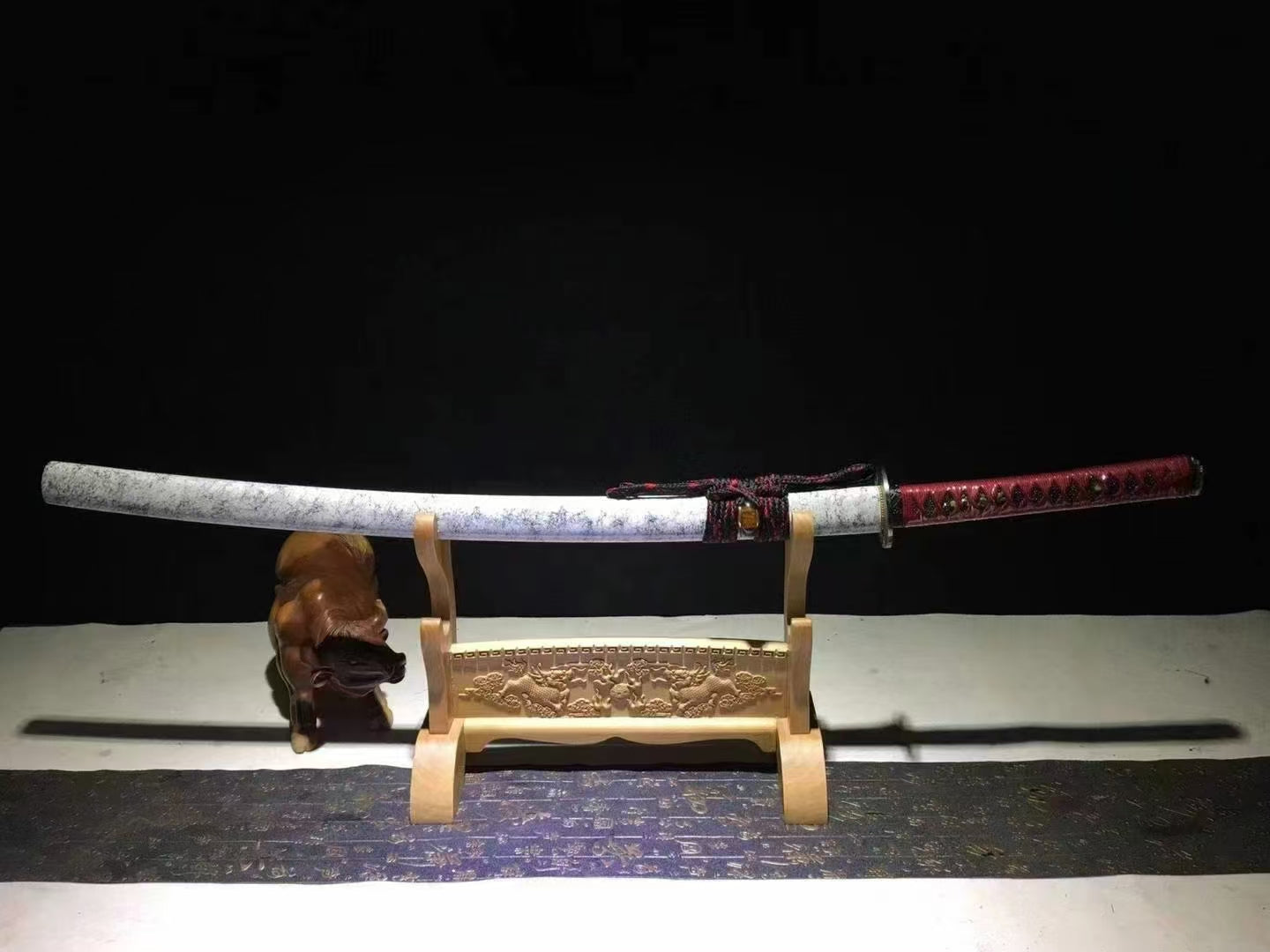 The complete Marble Blossom Katana, fully sheathed in its white marble-pattern saya, resting on a display stand.