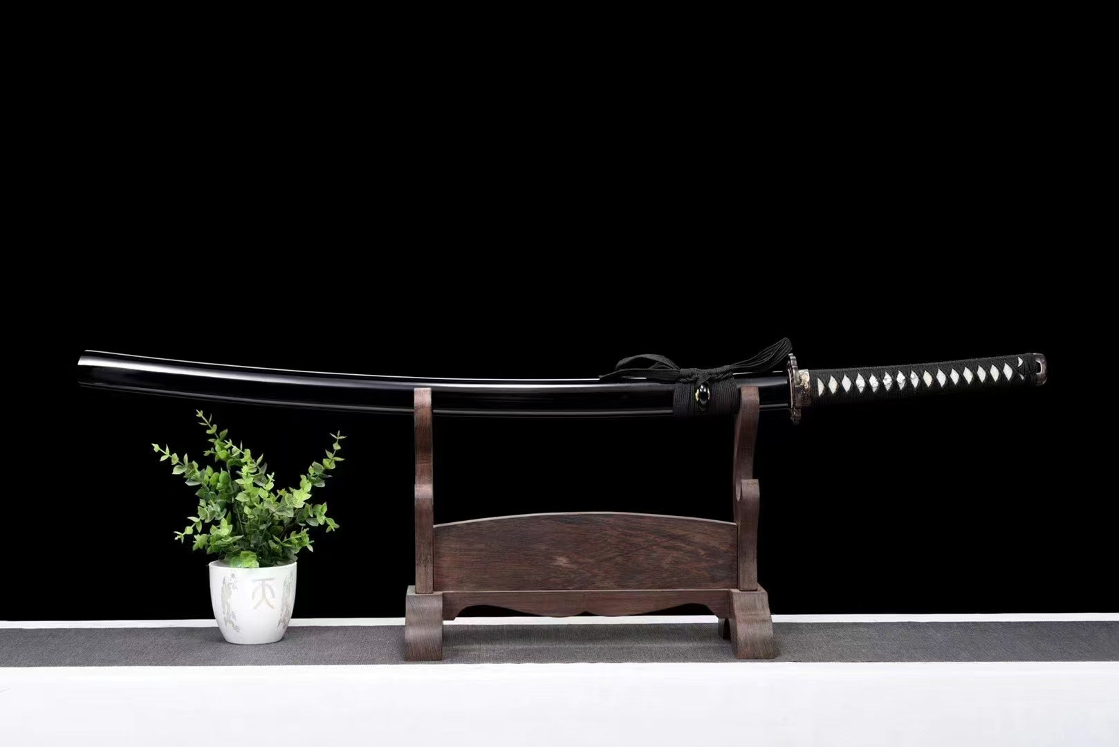 The complete Ryūjin's Fury Katana, fully sheathed in its gloss-black lacquer saya, resting on a display stand.