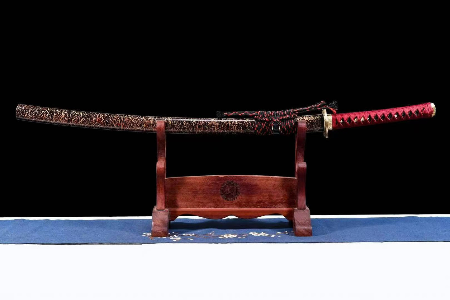 A side view of the sheathed Crimson Hitatsura Katana, highlighting the ornate koshirae.