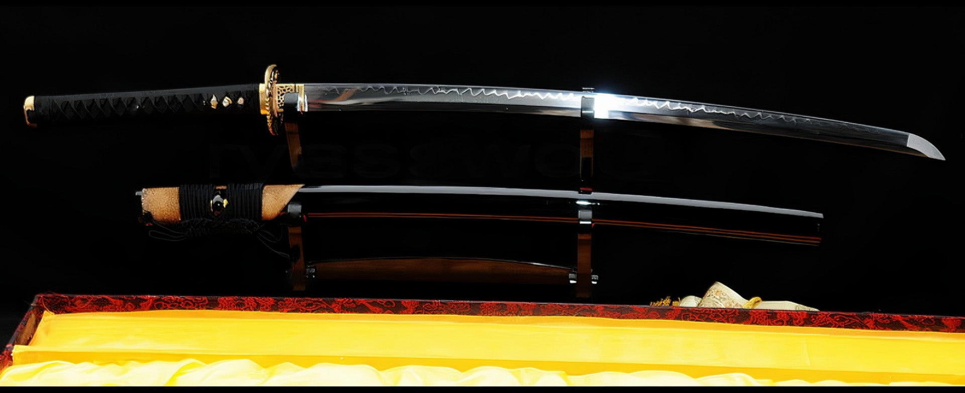 The unsheathed Golden Hawk Katana and its partial brown rayskin saya displayed on separate stands within a yellow-lined box.
