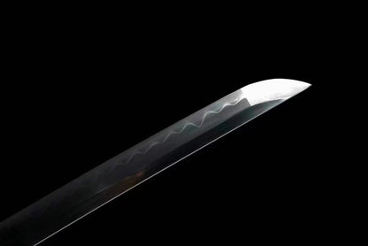 A detailed shot of the sharp chu-kissaki tip of the T10 steel blade, with the hamon visible.