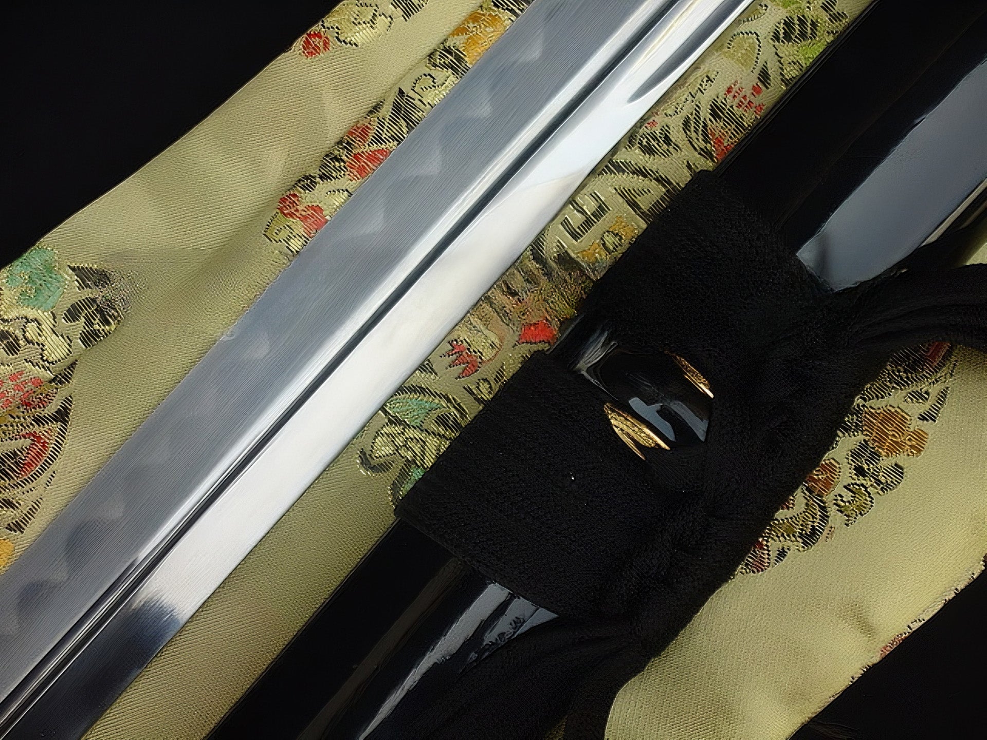 The mid-section of the through-hardened 1095 steel blade and the gloss-black saya, displayed side-by-side.