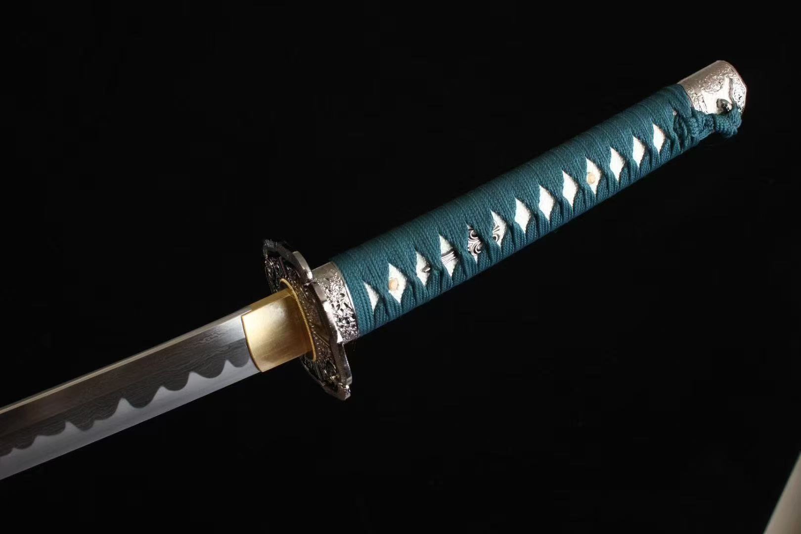 A close-up view of the tsuka handle, featuring the verdant green silk ito wrap over white genuine rayskin.