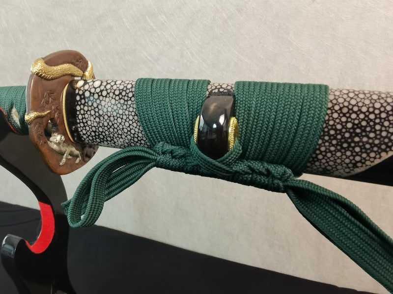 A close-up of the unique saya, featuring a half-wrap of white genuine rayskin and a green sageo cord.